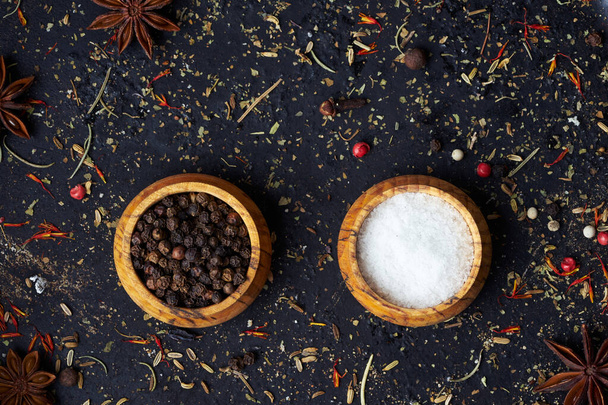 Closeup a salt and pepper shaker with spices on an old dark background with copy space. - 写真・画像