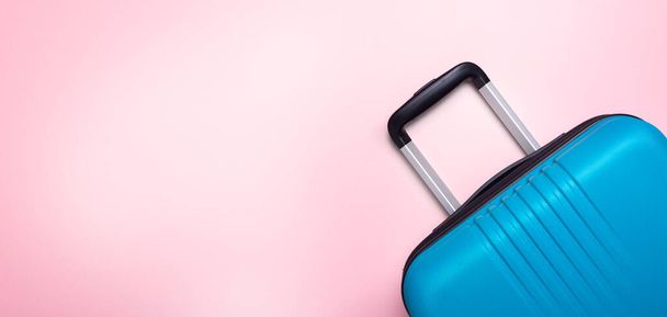 Blue suitcase on pastel pink background Summer holidays, vacation, travel concept Banner Minimal Copy space - 写真・画像