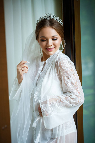beautiful bride in a wedding morning in a bathrobe and veil - Fotografie, Obrázek