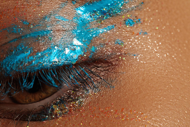 Macro Close-up Creative Art Eye Make-up. Cream Texture Colorful design on female Eye Lid. Beautiful female eye with aquamarine paint and bronze pigment - Photo, Image