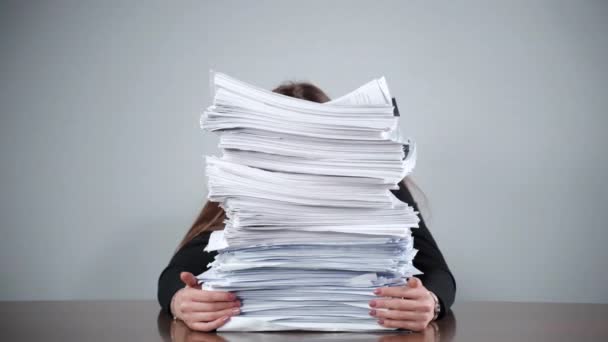 Stack of unfinished paperwork laying at the table in the office room, female accountant sitting behind the documents and files and feeling streesed from routine office work. Financial calculations - Footage, Video