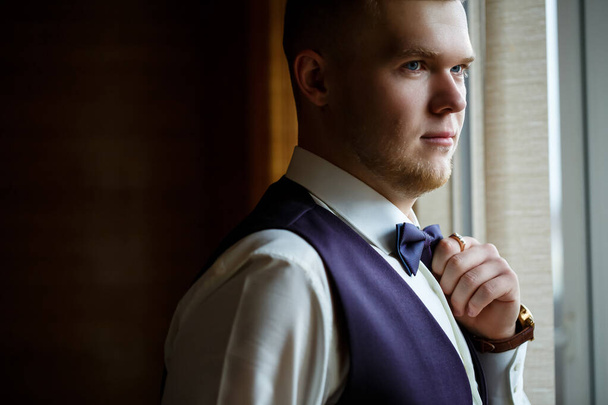 A guy in a white shirt and trousers dresses on a wedding day. - Photo, Image