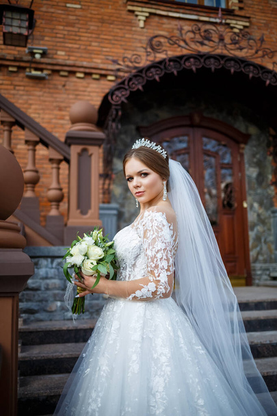 невеста в белом платье с букетом в руках и короной на голове
 - Фото, изображение