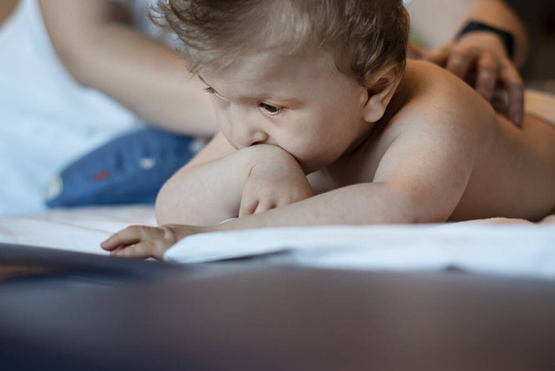 Baby met rugmassage in een revalidatiecentrum voor kinderen. Het kleine kind ontspant zich tijdens therapie. Massage therapeut masseren van een baby. - Foto, afbeelding