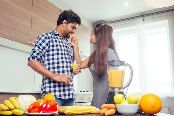 healthy and eco lifestyle.happy indian woman with her husband making smoothie in big kitchen - Foto, imagen