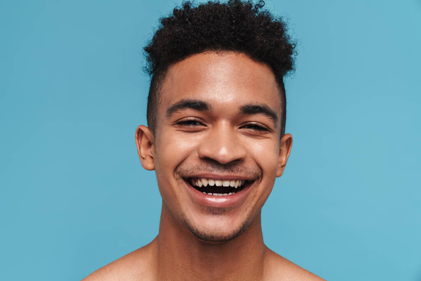 Photo of joyful african american man laughing and looking at camera isolated over blue background - Φωτογραφία, εικόνα