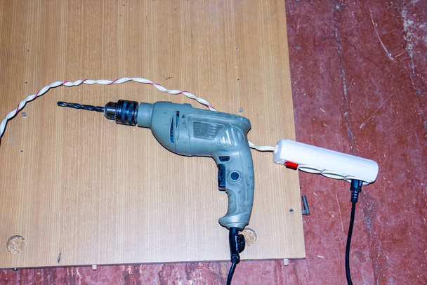 taladro eléctrico sobre madera, taladro eléctrico sobre fondo de madera
 - Foto, imagen