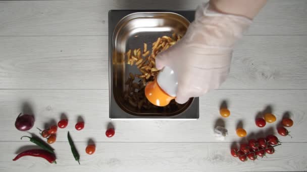 Chef en gants met du sel sur les frites chaudes et délicieuses
 - Séquence, vidéo