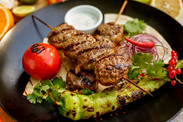 kebab pitaleipää ja grillattuja vihanneksia koristeltu pöytä
 - Valokuva, kuva