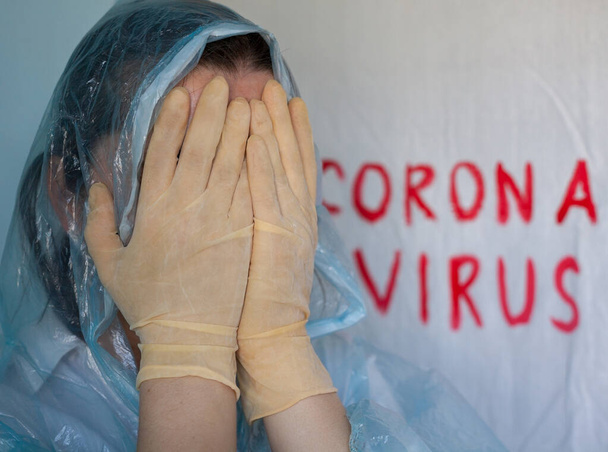 Donna in tuta protettiva che chiude il viso. Iscrizione Coronavirus sullo sfondo. Malattia di Coronavirus (Covid-19)
.  - Foto, immagini