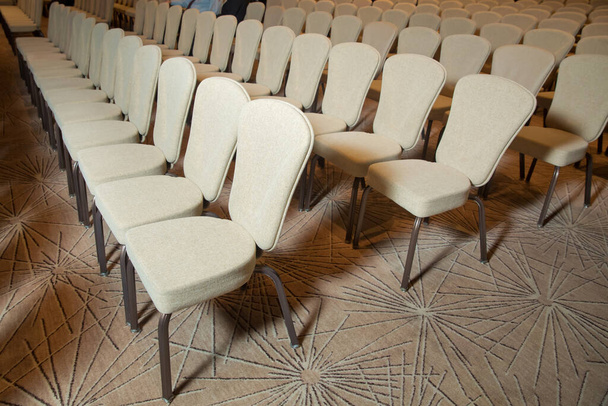 Білі стільці в конференц-залі незадовго до ділової зустрічі. Білі стільці в конференц-залі. порожнє місце в залі для зібрань - Фото, зображення