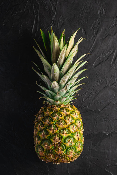 Fresh sweet pineapple on dark black textured background, top view copy space - Foto, Imagem