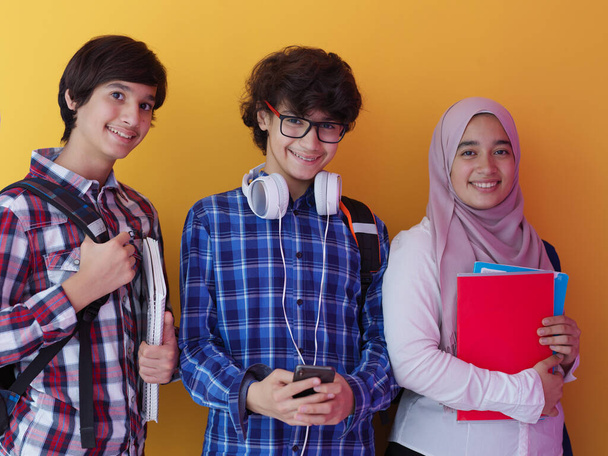 Arabo adolescenti come squadra, gruppo di studenti che lavorano insieme sul progetto utilizzando computer portatile e tablet online aula elearning concetto di istruzione sfondo viola
 - Foto, immagini