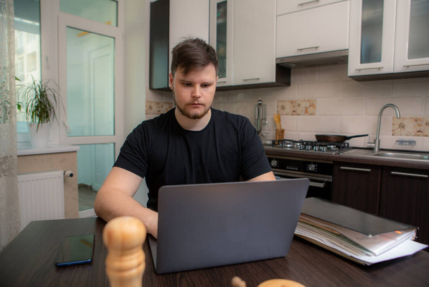 isolated man working at kitchen on laptop. domestic office - Photo, image