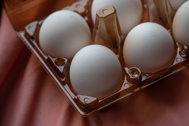 koncepce přírodních vajec. Podnos s vejci na bílo-růžovém pozadí. Eko tác s varlaty. minimalistický trend, pohled shora. Podnos s vajíčky. Vejce, kuřecí vejce. Eko produkt, organické potraviny. Velikonoce. vejce, eko - Fotografie, Obrázek