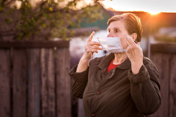 close up of face of mature woman show how to wear medical face mask. Protection from coronavirus - Фото, изображение