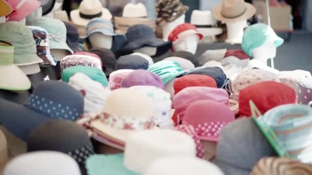 A pile of different types and styles of summer panama hats and caps displayed on local market counter. Trading on flea market, textile production, handmade accessories - Footage, Video