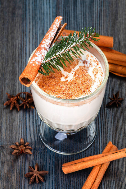 Traditional New Year or Christmas drink eggnog sprinkled  with grated nutmeg and cinnamon in a glass cup. - Foto, Imagen