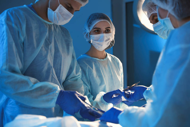 Team of professional surgeons performing operation in clinic - Φωτογραφία, εικόνα
