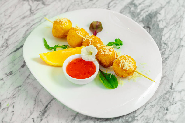 skewered cheese balls with sauce and lemon - Photo, Image