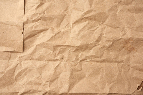 crumpled blank sheet of brown wrapping kraft paper, vintage texture for the designer, full frame - Valokuva, kuva