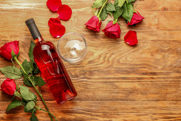 Composition with wine and roses on wooden background - Photo, image