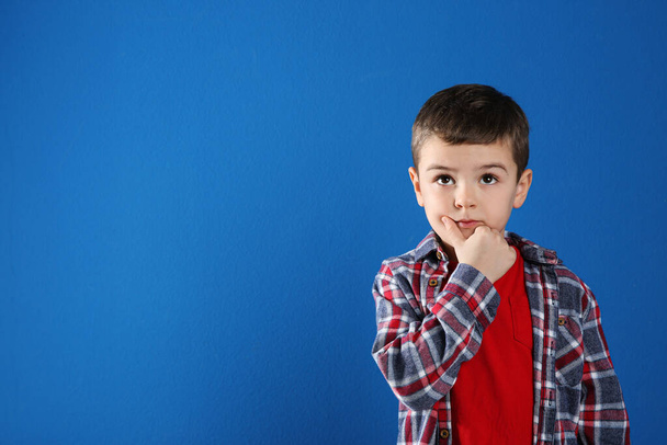Thoughtful little boy on blue background, space for text - Zdjęcie, obraz