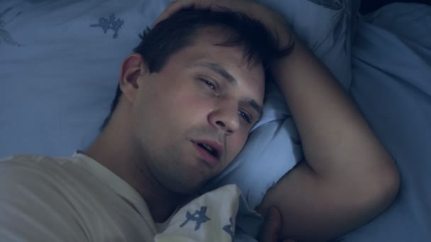 closeup. young man in bed at night coughing. the concept of disease - Imágenes, Vídeo