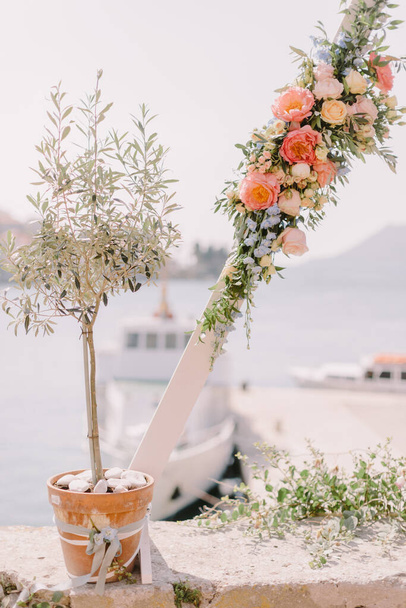 海の見える目的地の結婚式のアーチ。クロアチアの三角形の結婚式アーチ。ユニークな花のアーチと目的地の結婚式. - 写真・画像