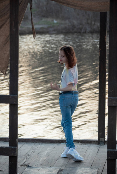 Portrét krásné mladé ženy. Plein air photo shoot near river. Portrét teenagera. Je jí 9 let. Školačky chodí blízko řeky. River. Dívka při jarním západu slunce - Fotografie, Obrázek