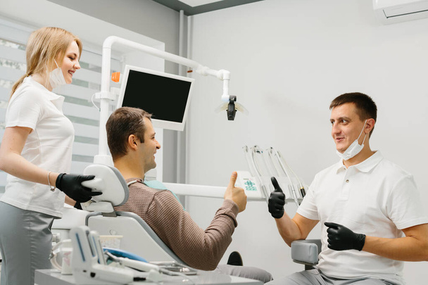 Man geeft duimen op bij tandartspraktijk - Foto, afbeelding