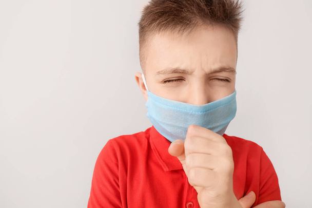 Ill little boy wearing protective mask on grey background. Concept of epidemic - Foto, Imagem