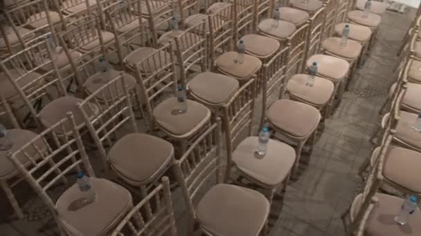 Aisles of chairs arranged for a wedding ceremony with water bottles ready for the guests - Footage, Video
