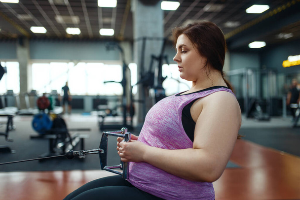 Egy túlsúlyos nő tornázik a sportklubban, fitneszedzést tart az oktatóval. Női személy küzd a túlsúly, aerob edzés az elhízás ellen, tornaterem - Fotó, kép