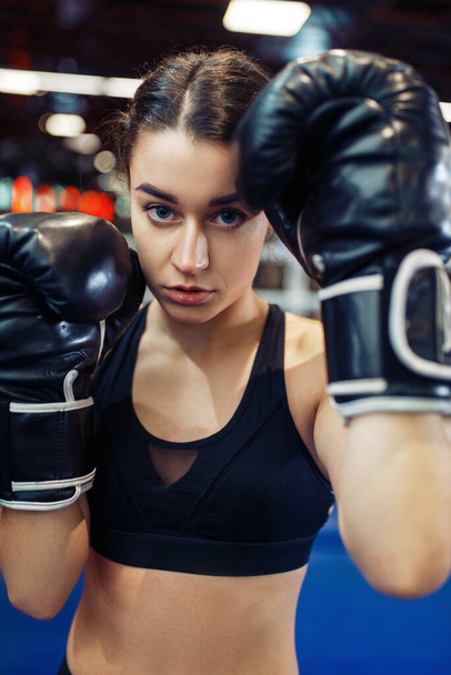 Woman in black boxing gloves in the ring, closeup front view, box training. Female boxer in gym, girl kickboxer in sport club, punches practice - Photo, Image