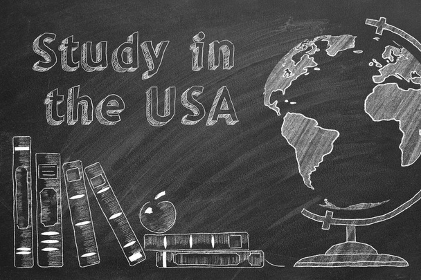 Písmena "Studium v USA", zeměkoule a školní knihy jsou kresleny křídou na tabuli. Studijní koncept v zahraničí. - Fotografie, Obrázek