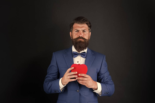 happy valentines day. tuxedo man with red heart. love and romance. ready for date. brutal bearded hipster in formal outfit. confident and successful businessman in suit with bow tie - Foto, imagen