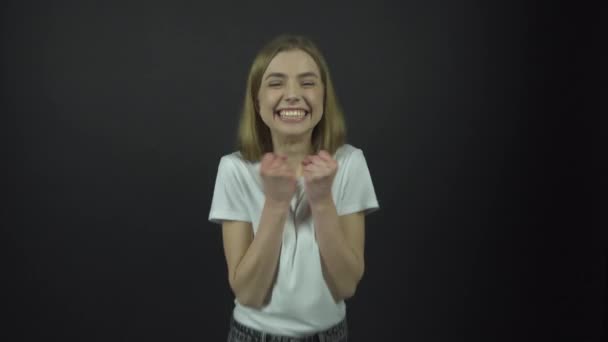 Девушка в белой футболке прыгает и пожимает руку от счастья
 - Кадры, видео