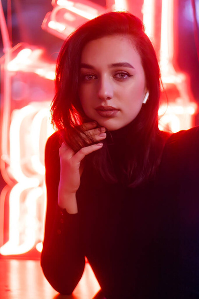 Phantom blue 2020 Trend.Portrait of a girl on the background of a neon sign of a shop window. Retrowave Style with Neon and Pink Lights. - Фото, изображение