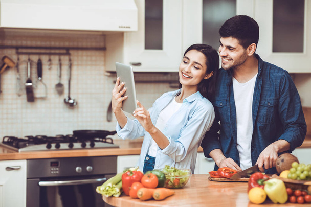 Lovely couple preparing salad together at home - Photo, Image