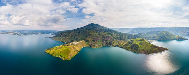 Aerial: λίμνη Toba και Samosir Island θέα από πάνω Σουμάτρα Ινδονησία. Τεράστια ηφαιστειακή καλντέρα που καλύπτεται από νερό, παραδοσιακά χωριά Batak, πράσινο ρύζι paddies, ισημερινό δάσος. - Φωτογραφία, εικόνα