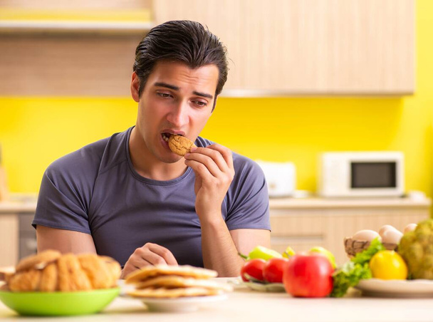 Man having hard choice between healthy and unhealthy food - Fotó, kép