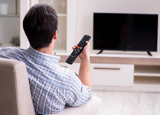 家でテレビを見ている若い男 - 写真・画像