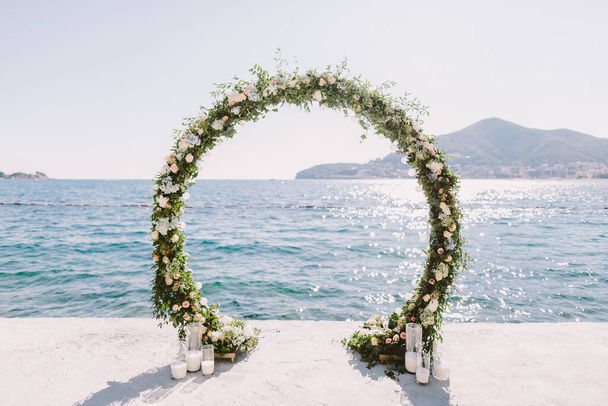 モンテネグロでの海の景色と結婚式のアーチの受け入れ.海と山の景色を望む白い結婚式のレセプション会場。結婚式会場. - 写真・画像