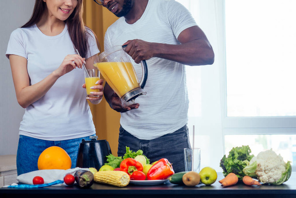 african american man with asian woman making smoothie at home - Photo, Image