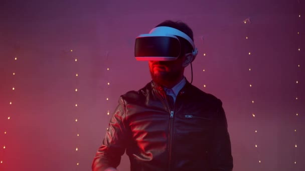 Professional engineer wearing virtual reality headset in small red illuminated room, man gesturing with hand and showing the turning of pages. Digital screen in augmented reality - Footage, Video