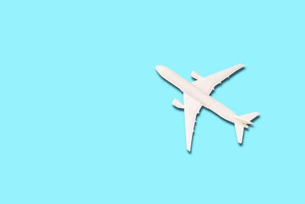 Model van wit vliegtuig op de lichtblauwe achtergrond met kopieerruimte - Foto, afbeelding