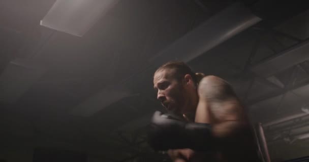 Male shadow boxing in dark gym - Video, Çekim