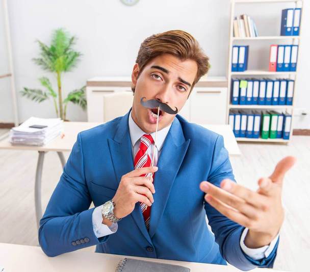 Веселий бісексуал з підробленими вусами в офісі
 - Фото, зображення