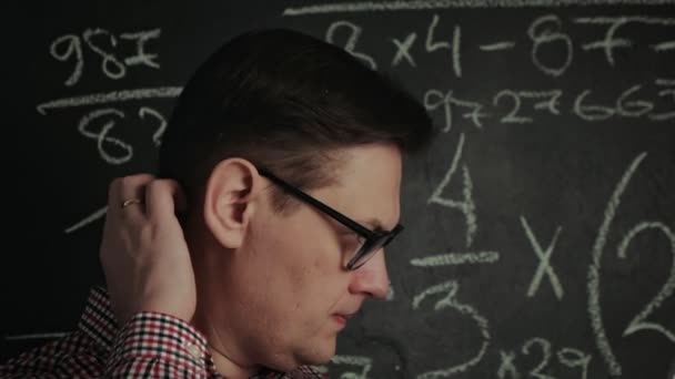 homem escreve fórmula matemática no quadro negro
 - Filmagem, Vídeo